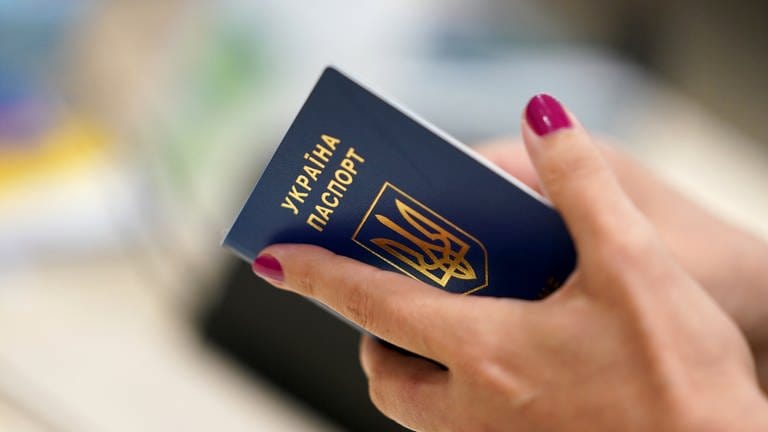 Eine Geflüchtete aus der Ukraine hält ihren Reisepass während der Registrierung in der Hand. (Foto: picture-alliance / Reportdienste, picture alliance/dpa | Marcus Brandt)