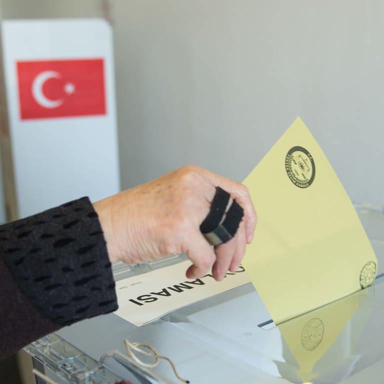 Eine Frau wirft in Stuttgart in einem Wahllokal vom türkischen Generalkonsulat einen Umschlag mit dem Wahlzettel in eine Wahlurne.  (Foto: dpa Bildfunk, picture alliance / Lino Mirgeler/dpa | Lino Mirgeler)