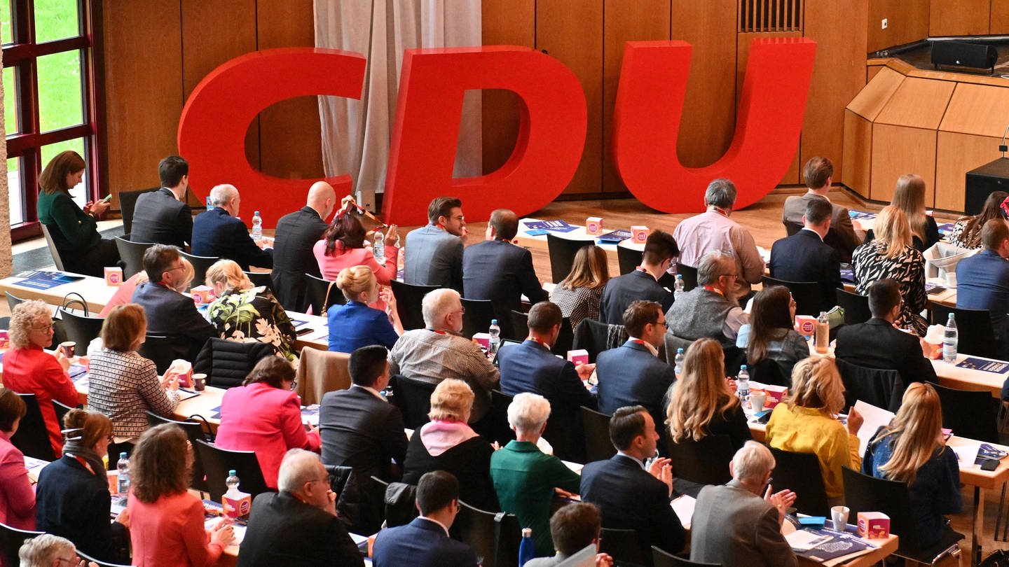 Die CDU-Vertreterinnen und -Vertreter hören vor einem CDU-Logo in der Filderhalle einer Rede auf der Landesvertreterversammlung zu. (Foto: dpa Bildfunk, picture alliance/dpa | Tom Maelsa)