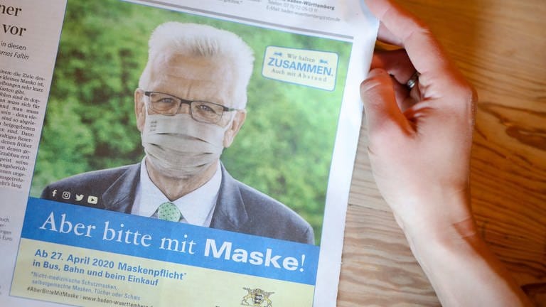 In der Stuttgarter Zeitung ist eine Anzeige der Landesregierung zu sehen, in der Ministerpräsident Winfried Kretschmann für das Tragen eines Mundschutzes wirbt. (Foto: dpa Bildfunk, picture alliance/dpa | Christoph Schmidt)