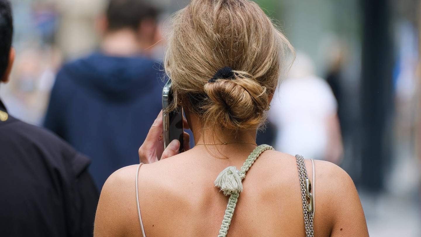 Eine Frau mit dem Telefon am Ohr in der Stadt. (Foto: IMAGO, Michael Gstettenbauer)