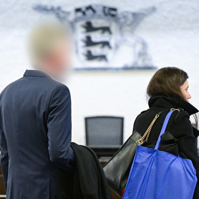 Der Angeklagte (l), inzwischen suspendierte Inspekteur der Polizei in Baden-Württemberg, kommt zu Beginn seines Prozesses mit seiner Anwältin in den Gerichtssaal. (Foto: dpa Bildfunk, picture alliance/dpa | Bernd Weißbrod)
