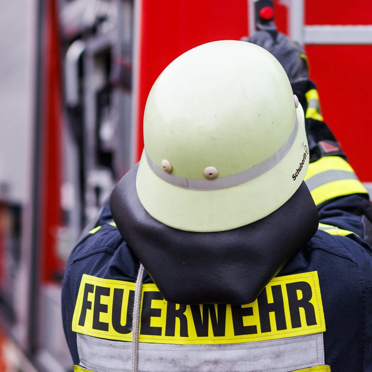 Ein Feuerwehrmann holt während einer Einsatzübung einer Freiwilligen Feuerwehr eine Leiter vom Dach eines Einsatzfahrzeugs.