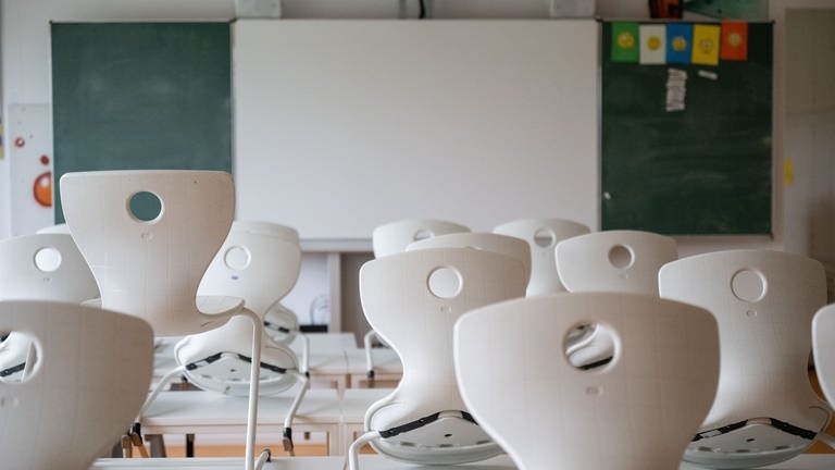 Stühle stehen in einem Klassenzimmer der Hanfbachschule auf Schultischen. 