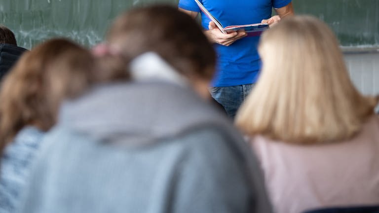 Ein Lehrer unterrichtet in einem Klassenzimmer einer Realschule.
