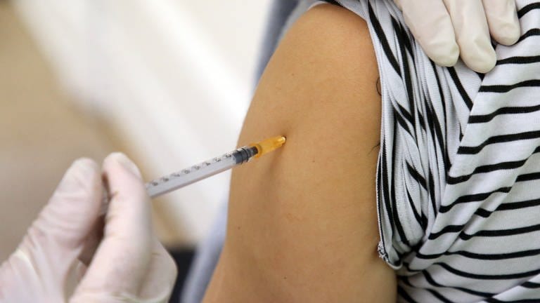 Eine Ärztin impft eine Frau mit einem neuen Corona-Impfstoff. Dieser ist ab Montag in den Arztpraxen verfügbar. (Archivfoto)