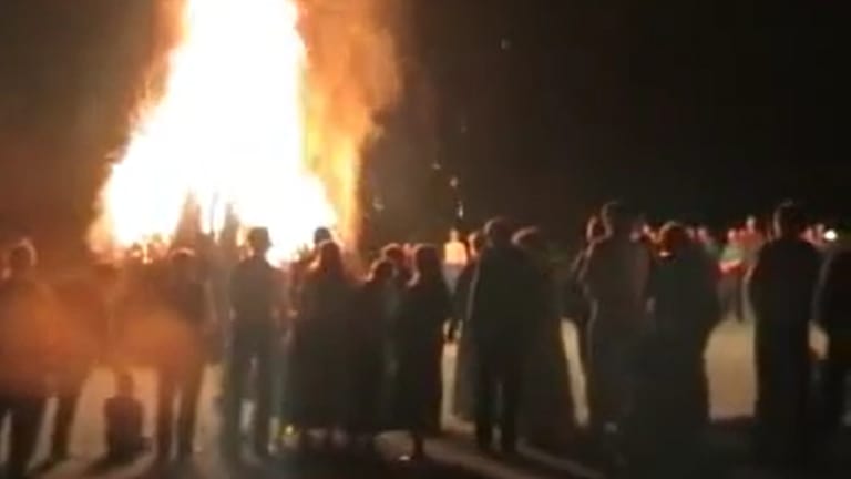 Menschen stehen um ein großes Feuer. (Foto: Aus einem Video auf dem YouTube-Kanal der Artgemeinschaft, der inzwischen nicht mehr aufrufbar ist. (Fotomontage SWR))