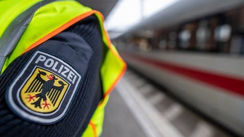 Ein Beamter der Bundespolizei steht am Hauptbahnhof in Freiburg vor einem ICE
