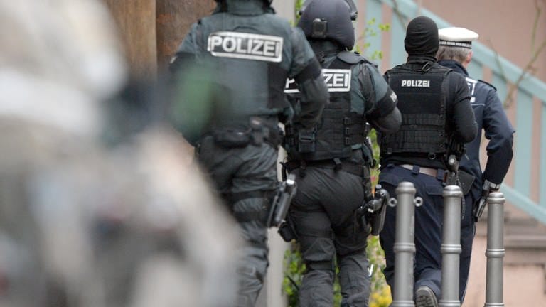 Polizeikräfte eines Sondereinsatzkommandos laufen bei einem Einsatz in Stuttgart zu einem Hauseingang, um ein Gebäude zu durchsuchen (Archivbild). (Foto: dpa Bildfunk, picture alliance / dpa | Bernd Weissbrod)