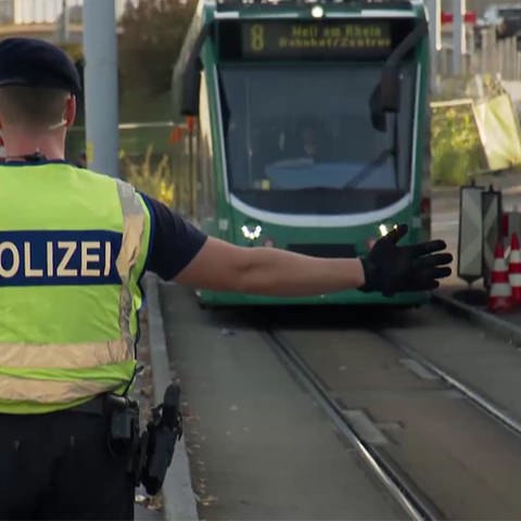 Polizist hält Straßenbahn an