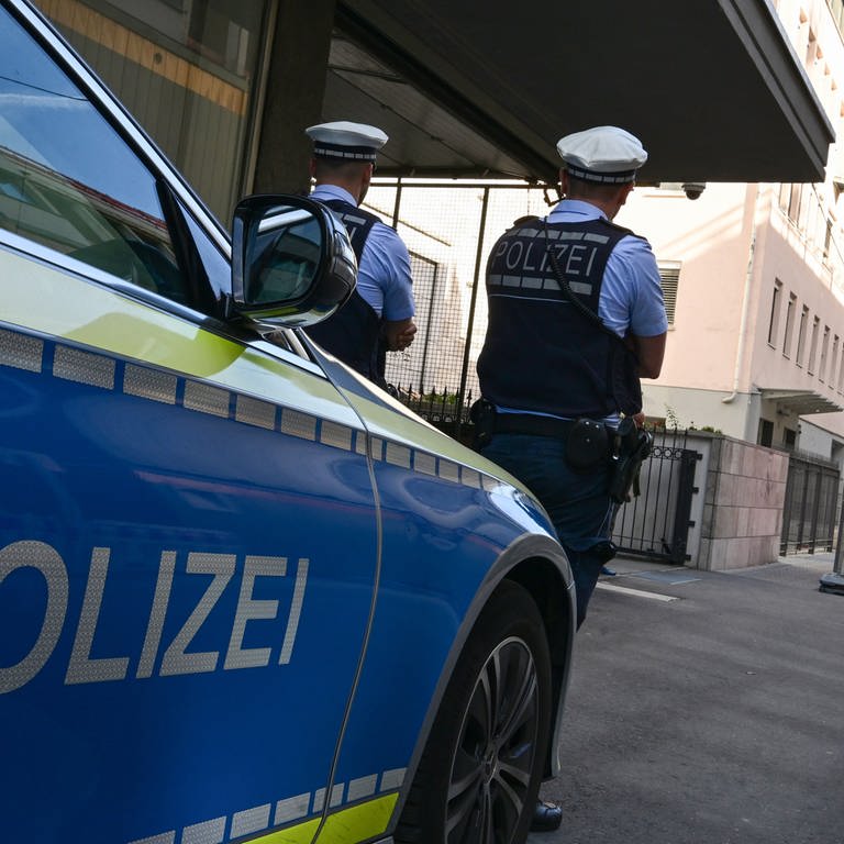 Zwei Polizisten stehen mit ihrem Streifenwagen vor einer Synagoge in Stuttgart.  (Foto: dpa Bildfunk, picture alliance/dpa | Bernd Weißbrod)