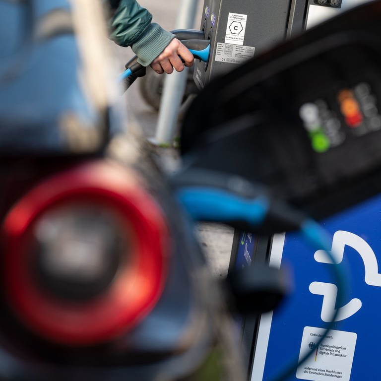 Eine Frau lädt in der Stuttgarter Innenstadt ihr Auto an einer Ladesäule des Energiekonzerns EnBW.