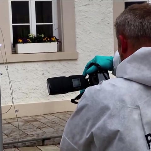 ein Kriminalbeamter fotografiert den Tatort (Foto: SWR)