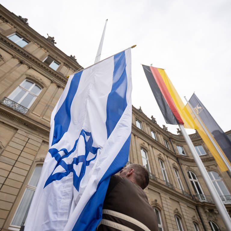 Die Flagge Israels wird von einem Mitarbeiter des Staatsministeriums Baden-Württemberg zwischen den Flaggen der EU, Deutschlands und Baden-Württembergs gehisst.  (Foto: dpa Bildfunk, picture alliance/dpa | Marijan Murat)