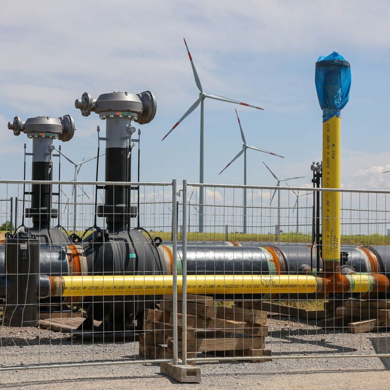 Die Rohre einer künftigen Wasserstoffleitung liegen vor der Kulisse eines Windparks in Bad Lauchstädt (Sachsen-Anhalt). Wird Wasserstoff aus nachhaltiger Energie gewonnen, spricht man auch von grünem Wasserstoff.