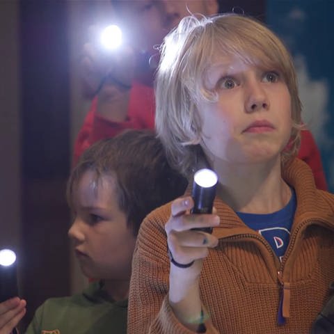 Kinder leuchten mit Taschenlampen