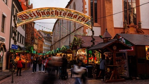 Menschen gehen über den Weihnachtsmarkt. 