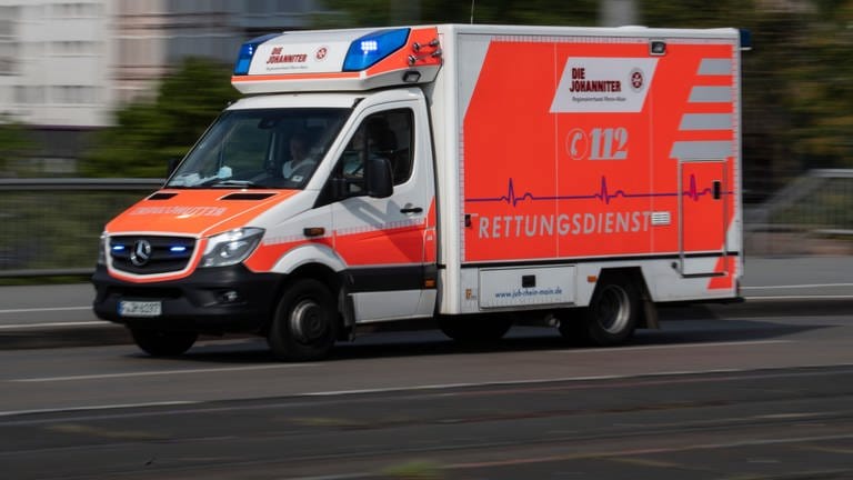 Mit eingeschaltetem Blaulicht fährt ein Rettungswagen auf einer Straße. Die Landesregierung in Baden-Württemberg muss die Hilfsfrist für Rettungsdienste neu regeln. Bisher sei das noch nicht passiert, meinen Richter. (Foto: dpa Bildfunk, picture alliance/dpa | Boris Roessler)