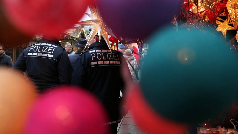 Zwei Polizeibeamte sind auf einem Weihnachtsmarkt als Fußstreife unterwegs.  (Foto: dpa Bildfunk, picture alliance / Thomas Warnack/dpa | Thomas Warnack (Archivbild))