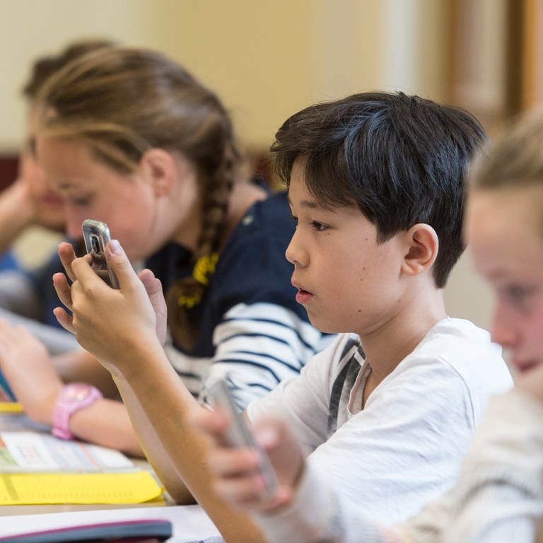 Baden-Württemberg, Freiburg: Schüler arbeiten im Friedrich-Gymnasium im Unterricht mit dem Smartphone.