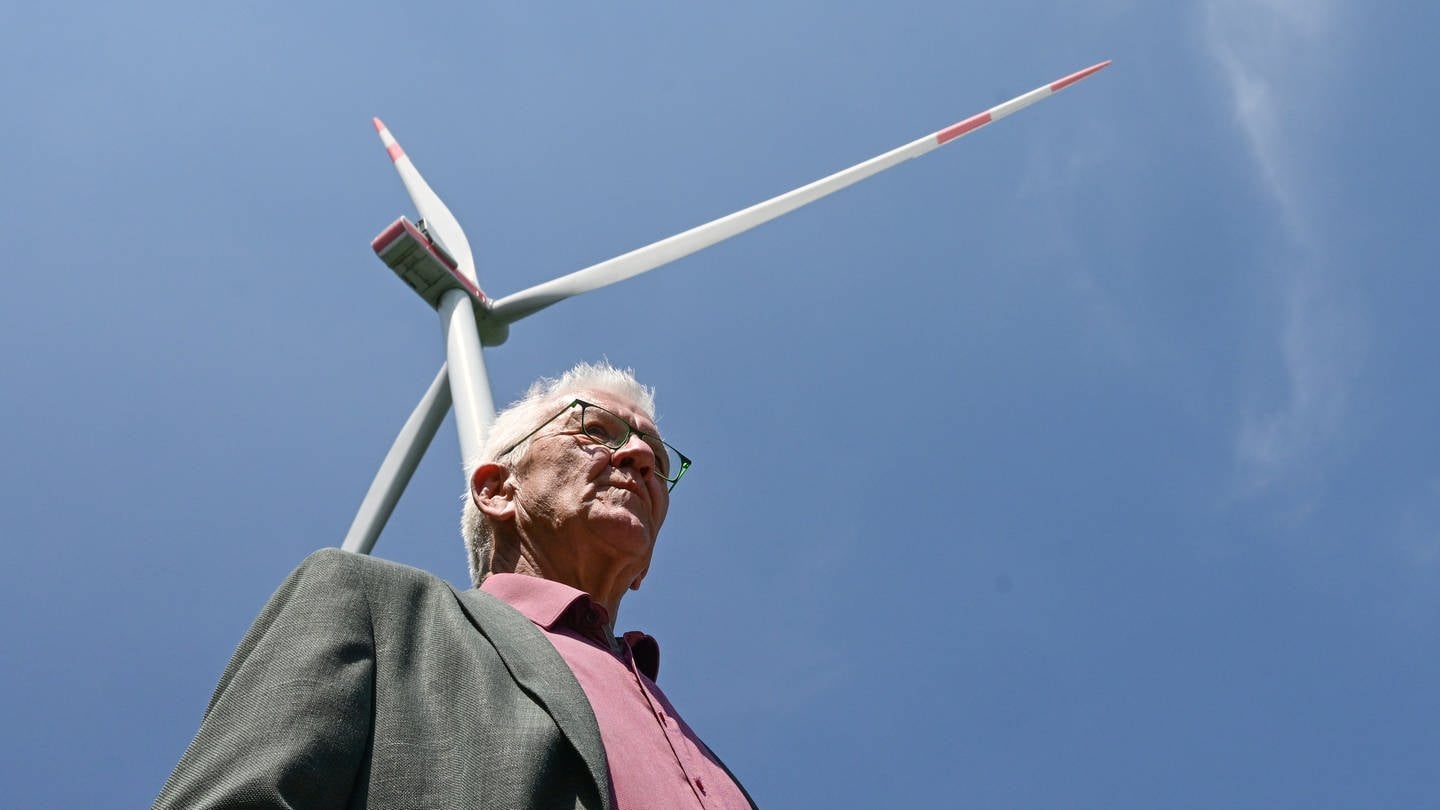 Archivbild: Winfried Kretschmann (Grüne) steht bei einer Besichtigung einer Baustelle einer Windkraftanlage vor einem schon gebauten Windrad. (Mai 2023) (Foto: dpa Bildfunk, Archivbild (picture alliance/dpa | Bernd Weißbrod))
