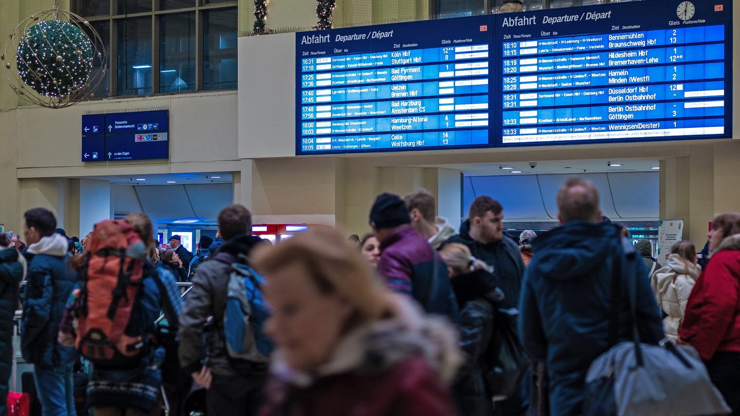 Zahlreiche Reisende warten am Abend im Hauptbahnhof vor einem Informationsschalter. Sturmtief 