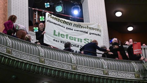 Aktivisten demonstrieren beim Dreikönigstreffen der FDP im Opernhaus mit einem Transparent. Darauf steht: "Menschen mitnehmen: Klimaschutz geht nur sozial gerecht"  (Foto: dpa Bildfunk, Picture Alliance)