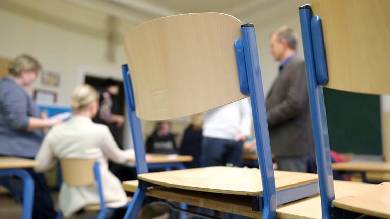 Stühle auf Tischen in einem Klassenzimmer. 