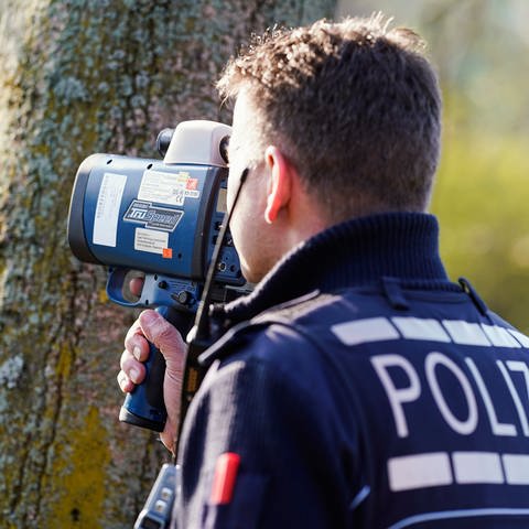 Ein Polizist kontrolliert mit einem Lasergerät an der Bundesstraße 36 die Geschwindigkeit von Fahrzeugen.  (Foto: dpa Bildfunk, picture alliance/dpa | Uwe Anspach)