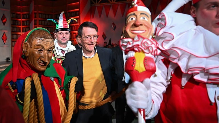 Karl Lauterbach (SPD), Bundesgesundheitsminister, wird von Laufnarren am Band in den Saal geführt.