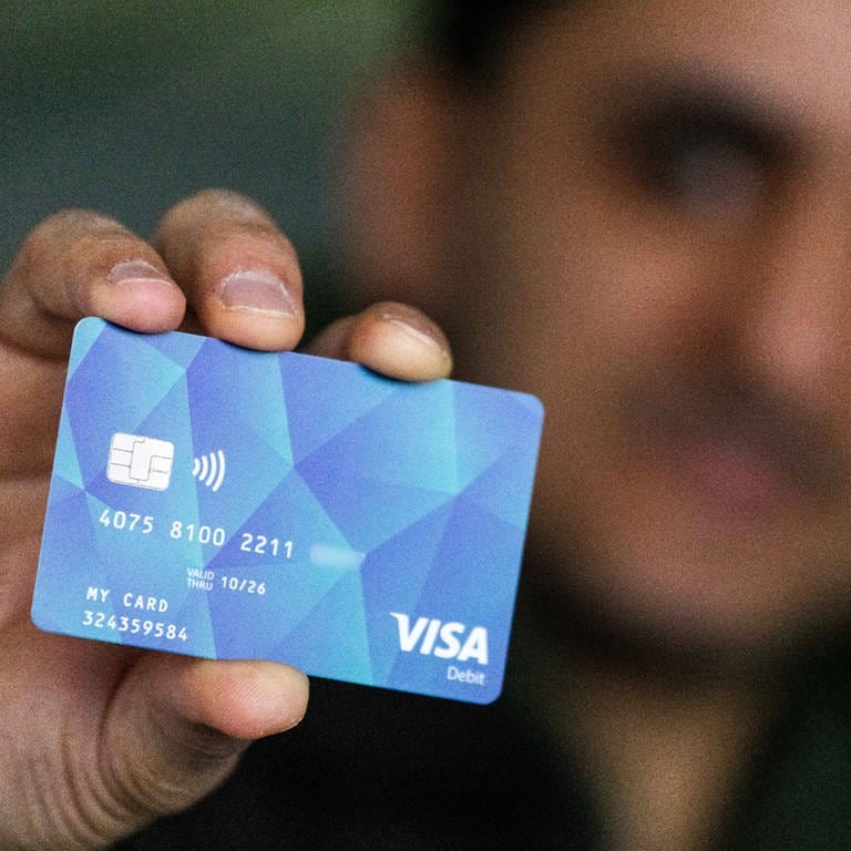 Ein Geflüchteter hält eine Debitcard in der Hand. Der Ortenaukreis hat bereits Mitte Januar die ersten Bezahlkarten für Geflüchtete ausgegeben. (Foto: dpa Bildfunk, picture alliance/dpa | Philipp von Ditfurth (Symbolbild))