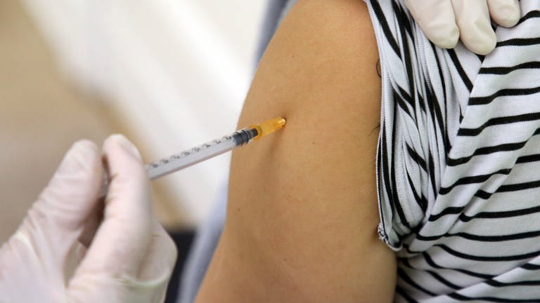 Eine Ärztin impft eine Frau mit einem Corona-Impfstoff.