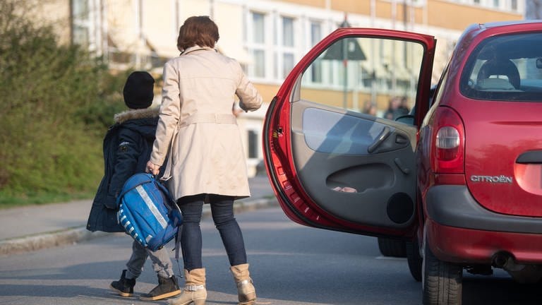 Eine Mutter bringt ihr Kind mit dem Auto zur Schule (Archiv)