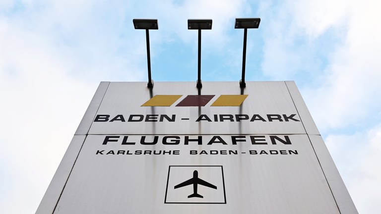 Eine Pylone mit der Aufschrift "Baden-Airpark Flughafen Karlsruhe Baden-Baden", aufgenommen vor der Einfahrt in den Flughafen.