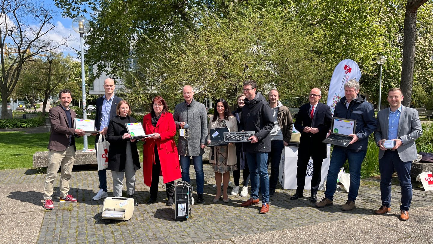 Vertreter der Gewerkschaft Erziehung und Wissenschaft (GEW) stehen mit alten Computern und Geräten vor dem baden-württembergischen Landtag. (Foto: SWR)