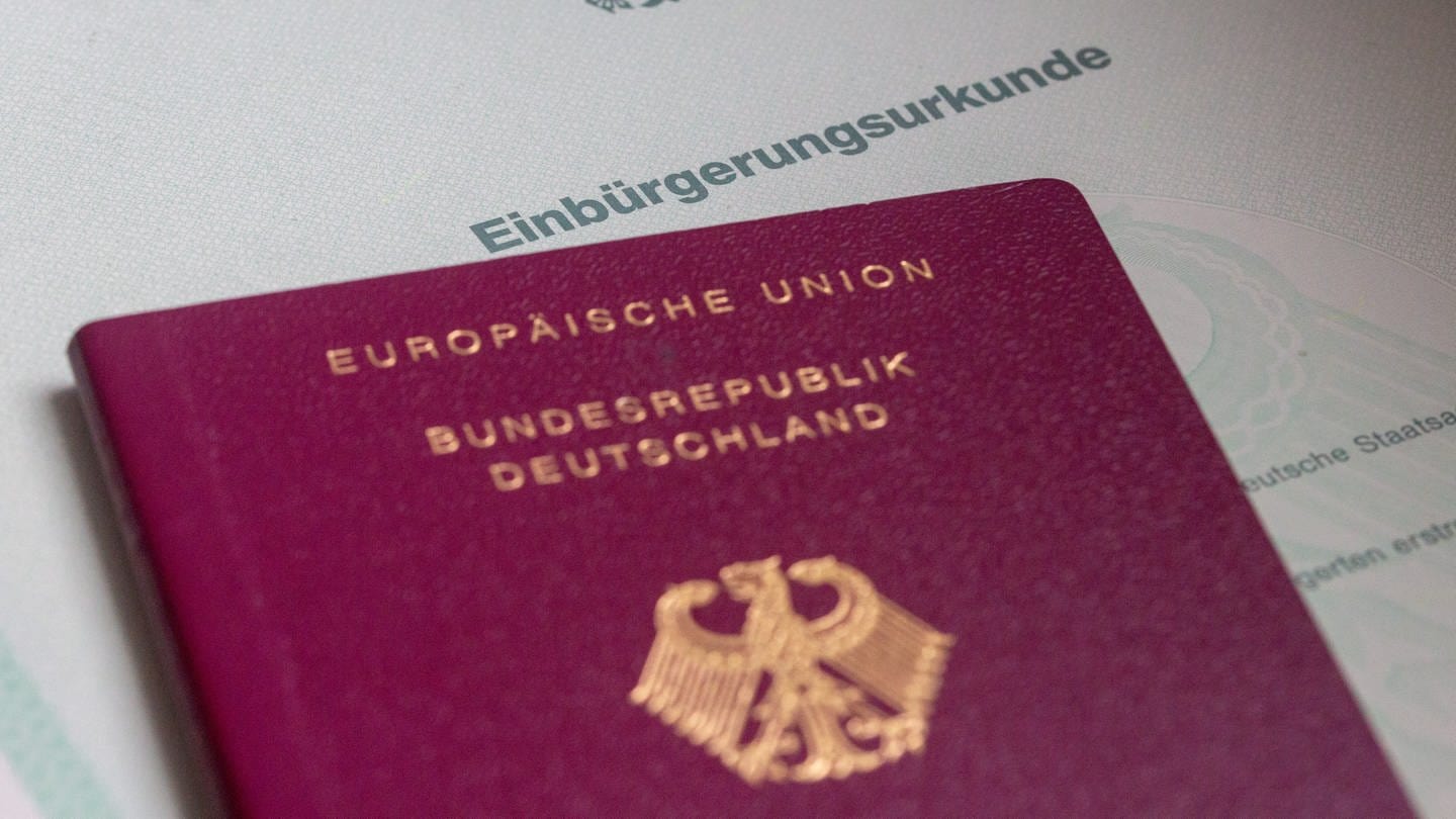 Eine Einbürgerungsurkunde der Bundesrepublik Deutschland und ein deutscher Reisepass liegen auf einem Tisch. (Foto: dpa Bildfunk, picture alliance/dpa | Fernando Gutierrez-Juarez)
