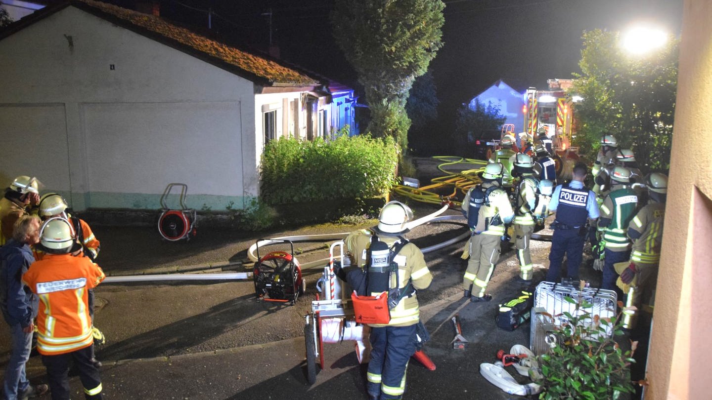 Einsatzkräfte von Feuerwehr und Polizei stehen am Abend um ein Haus. (Foto: René Priebe PR-Video)