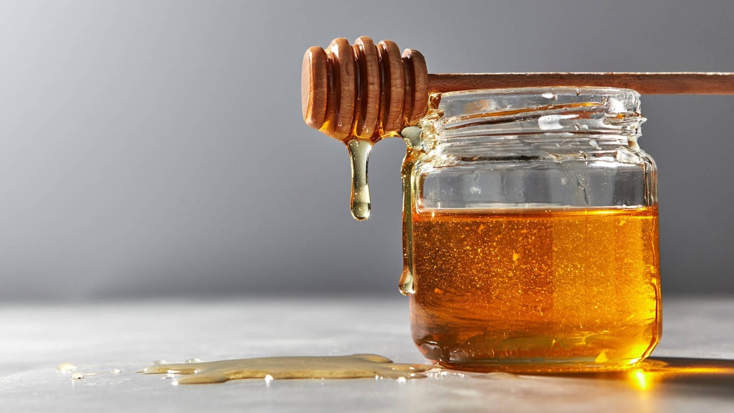 Honig tropft an einem Glas herunter. (Foto: IMAGO, IMAGO / Shotshop)