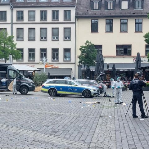 Mitarbeiter der Spurensicherung und Polizei sind nach einer Messerattacke auf dem Mannheimer Marktplatz im Einsatz