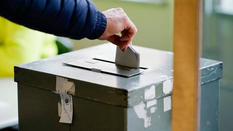 Ein Wählerin wirft in einem Wahllokal ihren Stimmzettel in die Wahlurne. 