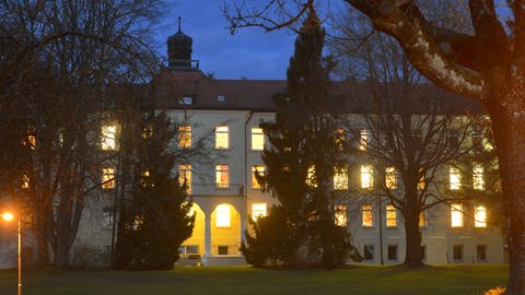 Das Bild zeigt das Krankenhaus Bad Waldsee bei Dunkelheit mit beleuchteten Zimmern. (Foto: Pressestelle, Oberschwabenklinik GmbH)