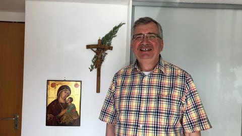 Diakon Gerhard Marquard steht vor einem Kreuz und einem Marienbild. (Foto: SWR, Thea Thomiczek)