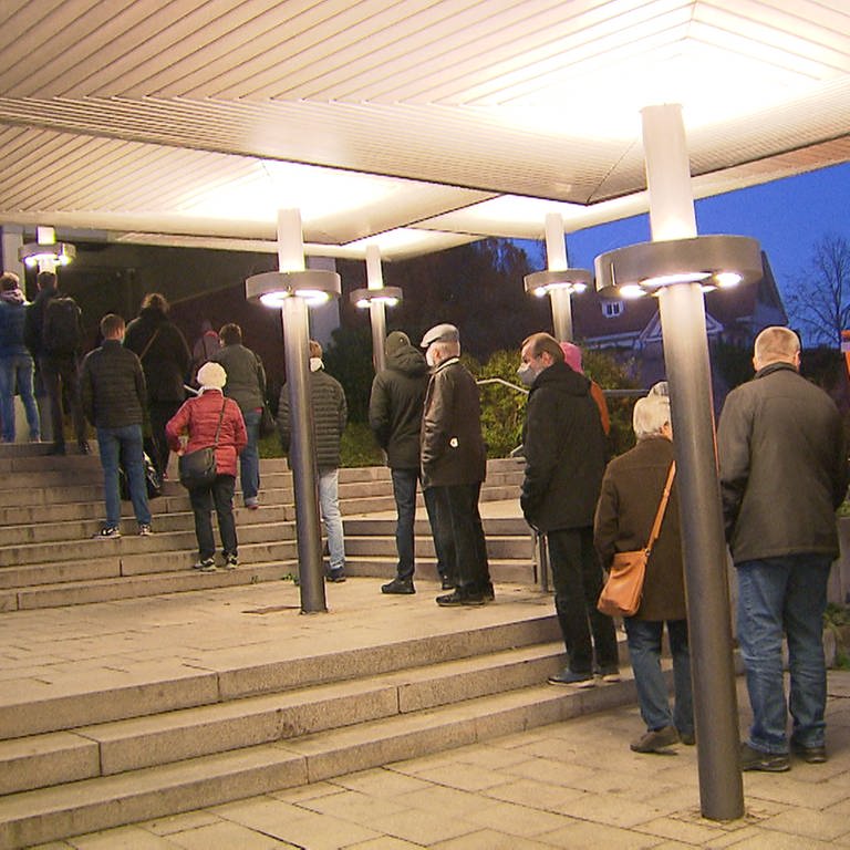 Menschen stehen vor dem neuen Impfzentrum in der Biberacher Stadthalle Schlange (Foto: SWR)
