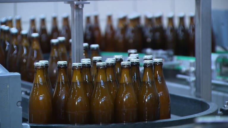 Flaschen laufen durch eine Abfüllanlange für Bier. (Foto: SWR)