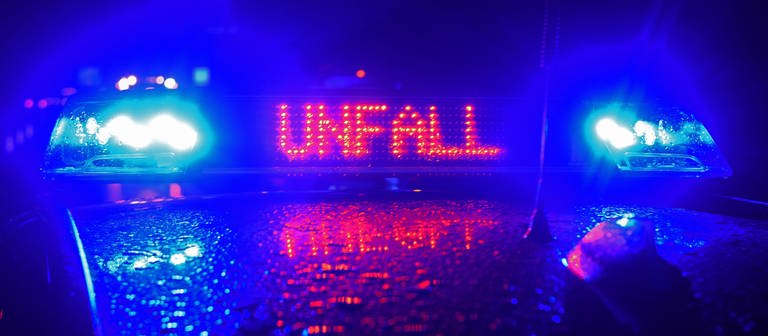 Dach eines Polizeifahrzeugs bei Dunkelheit, zwei blaue Lichter umrahmen rote Schrift "Unfall" (Foto: picture-alliance / Reportdienste, Picture Alliance)