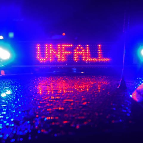 Dach eines Polizeifahrzeugs bei Dunkelheit, zwei blaue Lichter umrahmen rote Schrift "Unfall" (Foto: picture-alliance / Reportdienste, Picture Alliance)