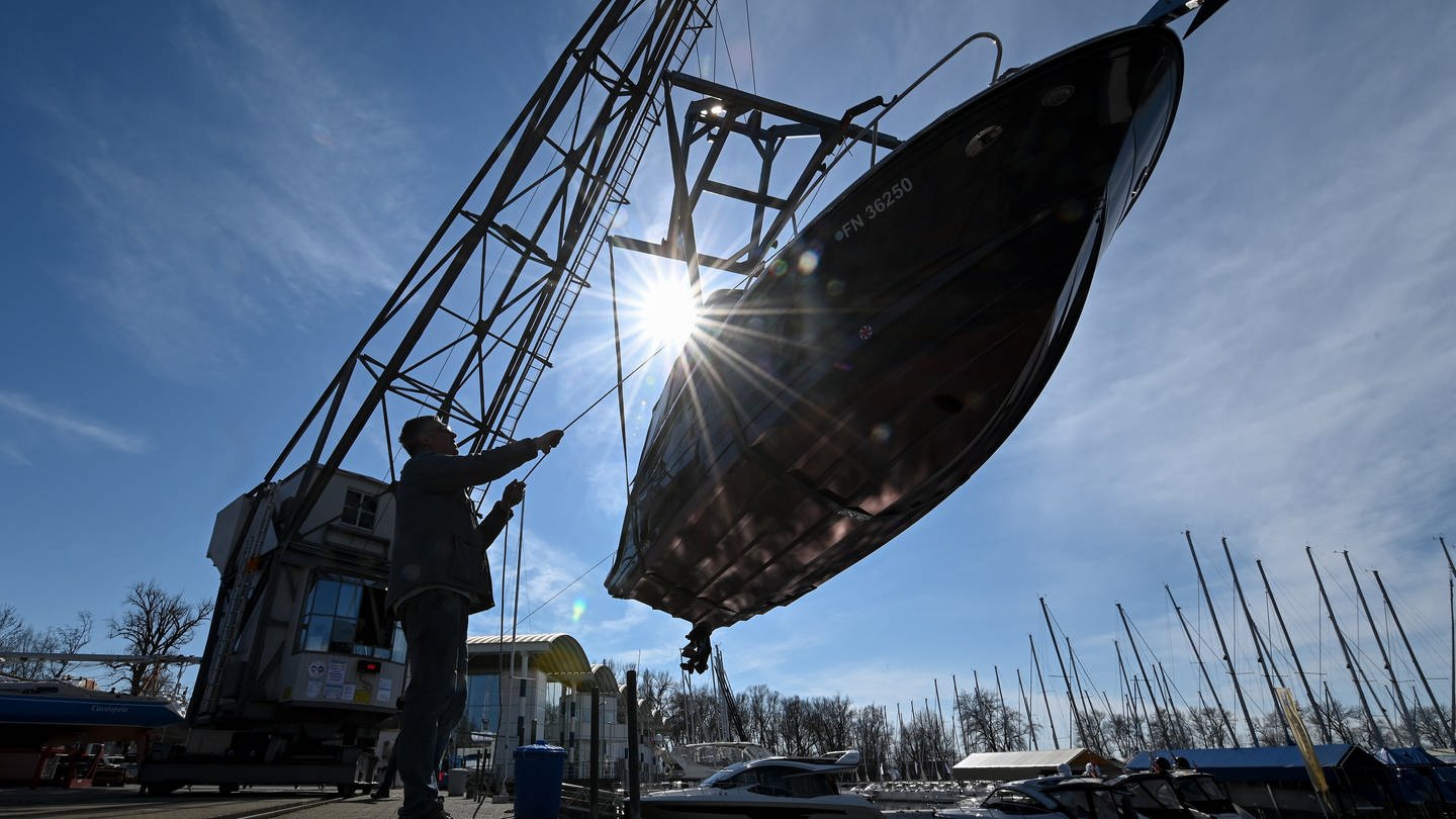 Ein Kran hievt eine kleine Yacht in den Yachthafen am Bodensee (Foto: picture-alliance / Reportdienste, Felix Kästle)
