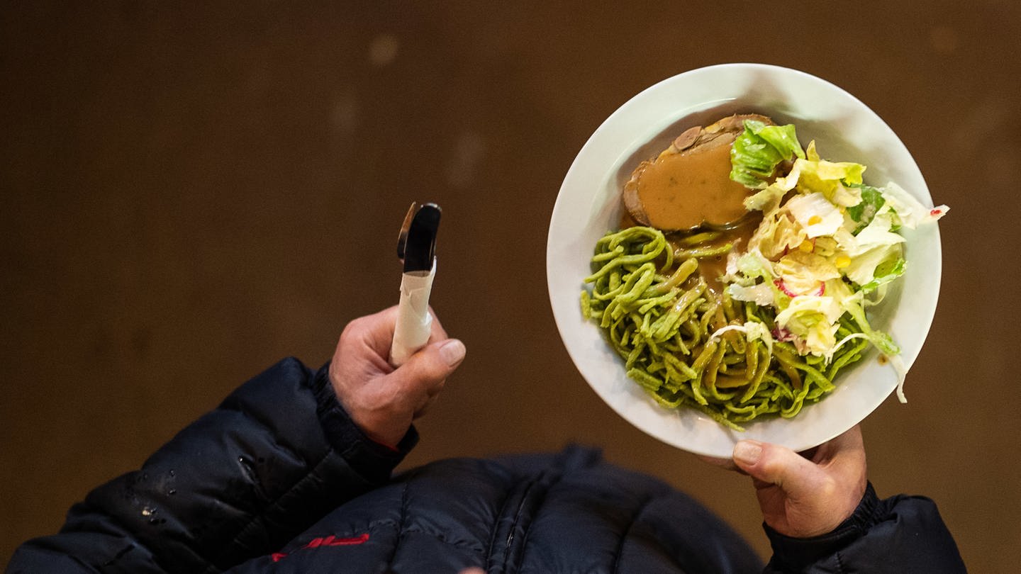 Ein Mann geht während des ersten Tags der Vesperkirche mit einem Teller Essen durch die Kriche. (Foto: dpa Bildfunk, picture alliance/Sebastian Gollnow/dpa)