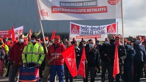 Männer stehen mit IG Metall Fahnen und roten Pfeifen auf einem Platz. (Foto: Pressestelle, IG Metall Bodensee-Oberschwaben)