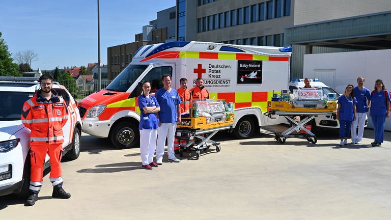 Mehrere Notfallsanitäter und Mitarbeiter der Oberschwabenklinik zeigen den neuen Babynotfallwagen. (Foto: Pressestelle, Oberschwabenklinikverbund)